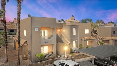 Back of house at dusk with stucco siding and a balcony