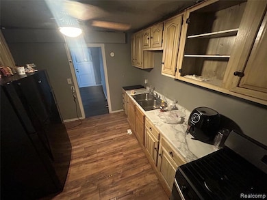 Kitchen featuring black appliances, light countertops, dark wood finished floors, and open shelves