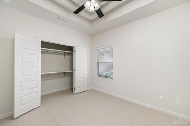 Unfurnished bedroom featuring ceiling fan, visible vents, baseboards, a closet, and a raised ceiling