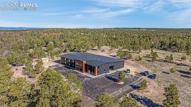 Aerial view of property and surrounding area with a heavily wooded area