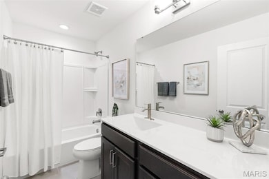 Full bathroom with tile patterned flooring, shower / bath combo, vanity, and toilet