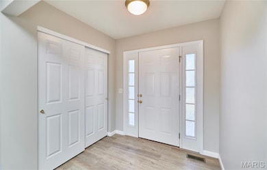 Entryway featuring baseboards and light wood-style flooring