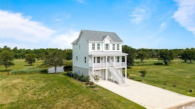Coastal inspired home with a porch, driveway, a front yard, and stairway