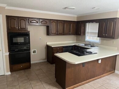Kitchen featuring kitchen peninsula, light tile pa