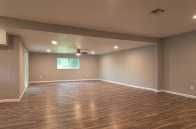 Charming room with hardwood floors and a modern ceiling fan. The warm wood tones create a cozy atmosphere, perfect for relaxing or entertaining. A great space to showcase your interior design style.

