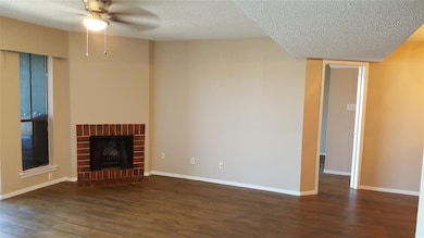 Unfurnished living room featuring baseboards, a te