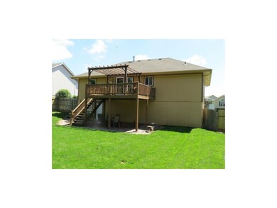 Back of house with wood deck and patio