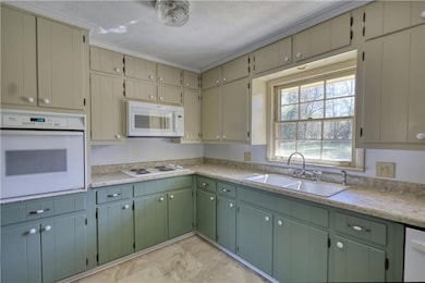 Kitchen with white appliances, light countertops, 