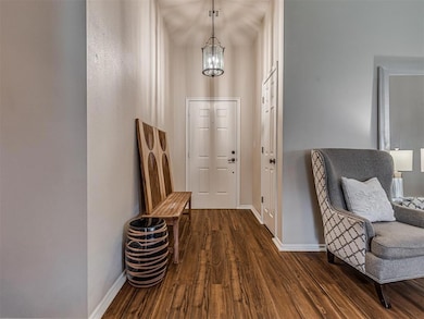 Entryway featuring dark wood-style flooring and a chandelier