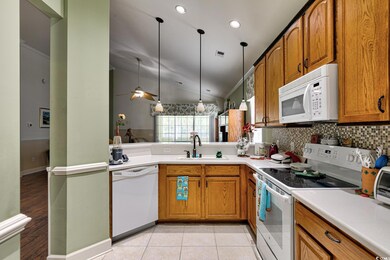 Kitchen with white appliances, sink, lofted ceilin