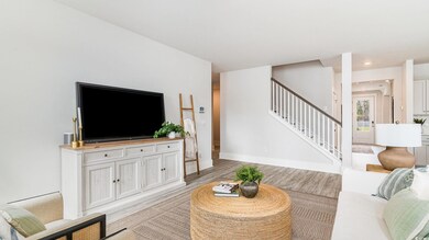 Living room featuring stairway, light wood-style floors, and baseboards