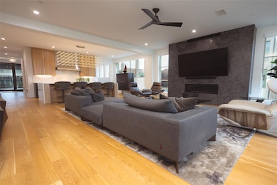 Living room featuring a large fireplace, hardwood 