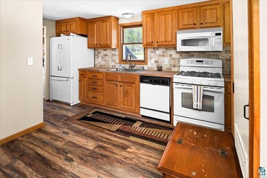 Kitchen featuring backsplash, sink, dark hardwood 