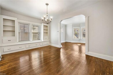 Dining room featuring a notable chandelier, dark hardwood flooring, and built in shelves