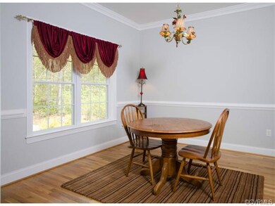 The dining room has fresh paint, hardwood floor, crown molding and chair rail.