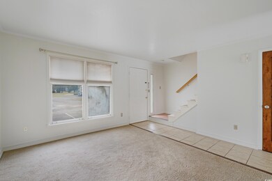 Carpeted entryway with tile patterned flooring, stairway, and baseboards