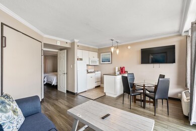 Living room with ornamental molding and hardwood / wood-style floors