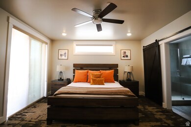 Bedroom featuring a barn door and ceiling fan