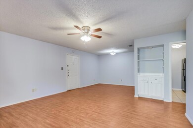 Unfurnished living room featuring ceiling fan, li