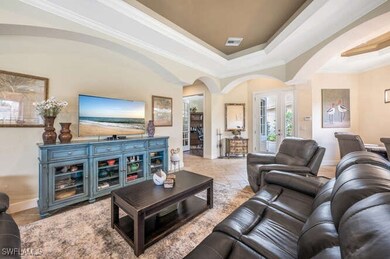Living room with a tray ceiling and ornamental mol