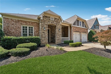 View of front of property featuring driveway, a front yard, a shingled roof, and brick siding