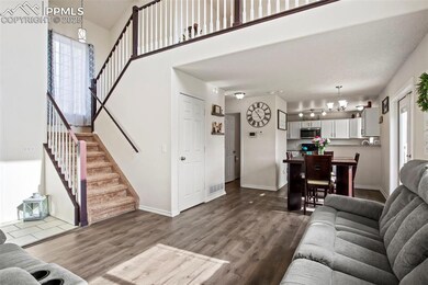Living area featuring stairway, dark wood-style floors, and baseboards