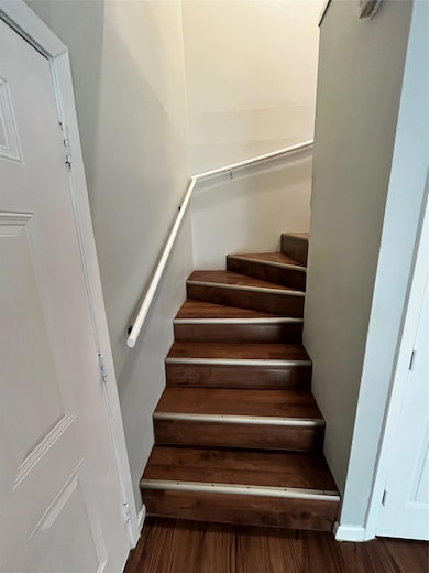 Stairs featuring wood finished floors and baseboards