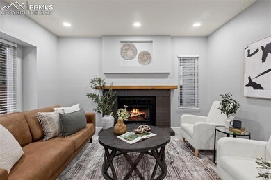 Living room with a fireplace, baseboards, wood fin