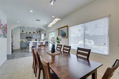 Dining room with light tile patterned floors, arch