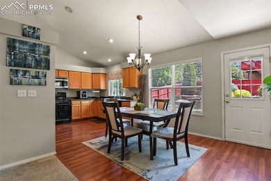 Dining area with a chandelier, baseboards, recessed lighting, vaulted ceiling, and dark wood-style floors