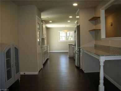 Dining Room: Room features include vinyl plank flooring for easy cleaning, fresh paint and recessed lighting. To the right side is a nice snack bar with granite top - some shelves for decorations and the opening through the wall to the living room. On the left is a decorative cabinet that will convey at closing. The kitchen and den are to the far end of the picture.