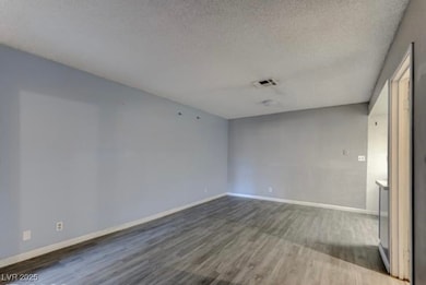 Empty room featuring a textured ceiling, baseboard