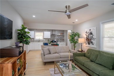 Living room with light wood-style floors, plenty of natural light, a ceiling fan, and recessed lighting