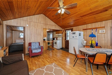 Living room featuring wood walls, light hardwood /