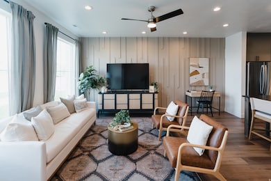 Living room featuring dark wood finished floors, recessed lighting, and a ceiling fan