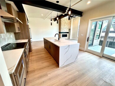 Kitchen featuring a stone fireplace, a center isla