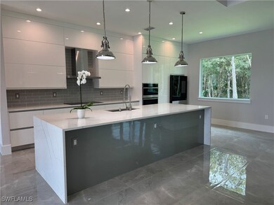 Kitchen with a sink, fridge, modern cabinets, and