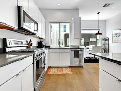 Kitchen with white cabinets, visible vents, a sin