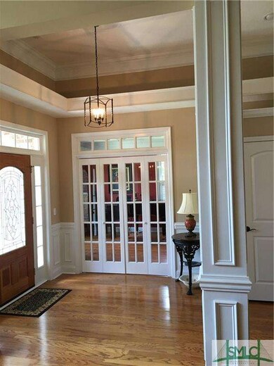 Foyer with hardwood floors and beautiful plant she