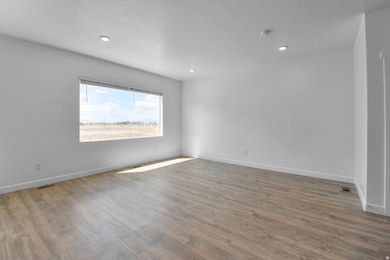 Empty room featuring light wood finished floors, recessed lighting, and a textured ceiling