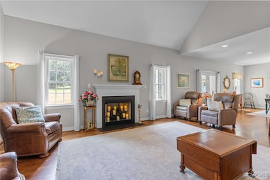 Living room featuring vaulted ceiling, a gas firep