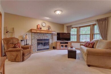 The cozy living room features a bay window and sto