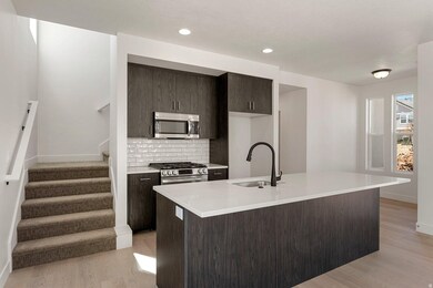 Kitchen featuring dark brown cabinets, tasteful backsplash, stainless steel appliances, light wood-style floors, and recessed lighting