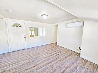 Entryway with a wall unit AC, wood finished floors