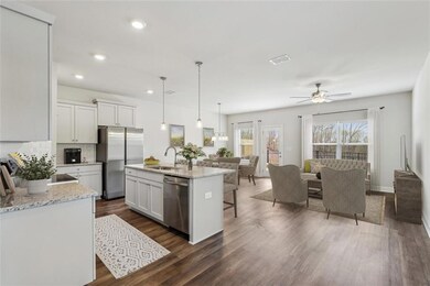 Kitchen with white cabinetry, dark hardwood / wood