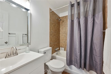 Full bathroom with tiled shower / bath combo and sleek vanity and fixtures