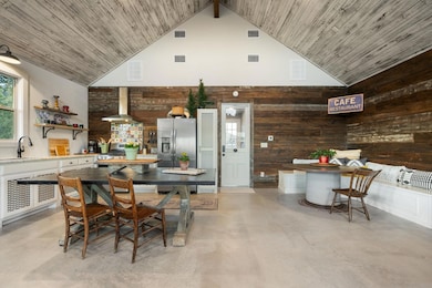 Dining area with high vaulted ceiling, wooden wal