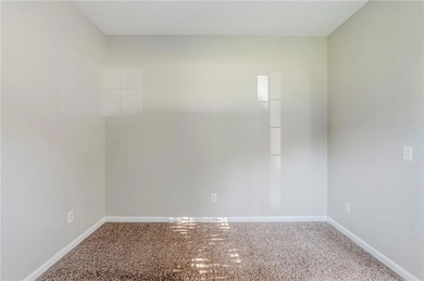 Carpeted empty room with baseboards