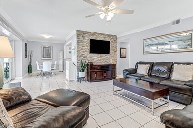 Living room featuring ornamental molding, light ti