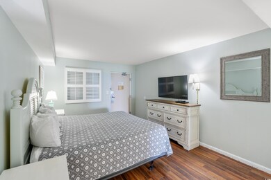 Bedroom with dark hardwood / wood-style flooring